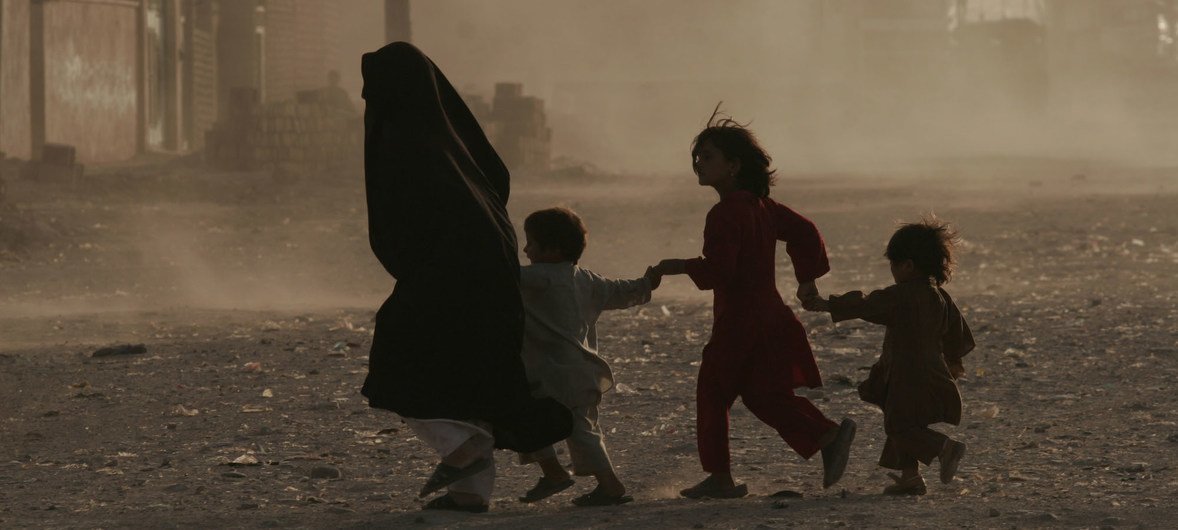 A family crosses a dusty street in Herat, Afghanistan.