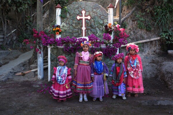 Catholic children representing angels pose for photos prior to join the Palm Sunday commemoration in Santa Cruz Chinautla, Guatemala, Sunday, March 29, 2026. (AP Photo/Moises Castillo)