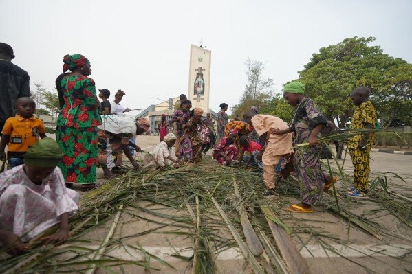 Catholic faithfuls collect palm fronds to commemorate Palm Sunday, outside St. Micheal's Cathedral church, in Minna, Nigeria, Sunday, March 29, 2026. (AP Photo/Sunday Alamba)