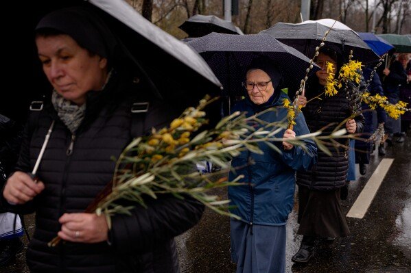 Catholic nuns walk during a Palm Sunday procession in Bucharest, Romania, Sunday, March 29, 2026. (AP Photo/Andreea Alexandru)