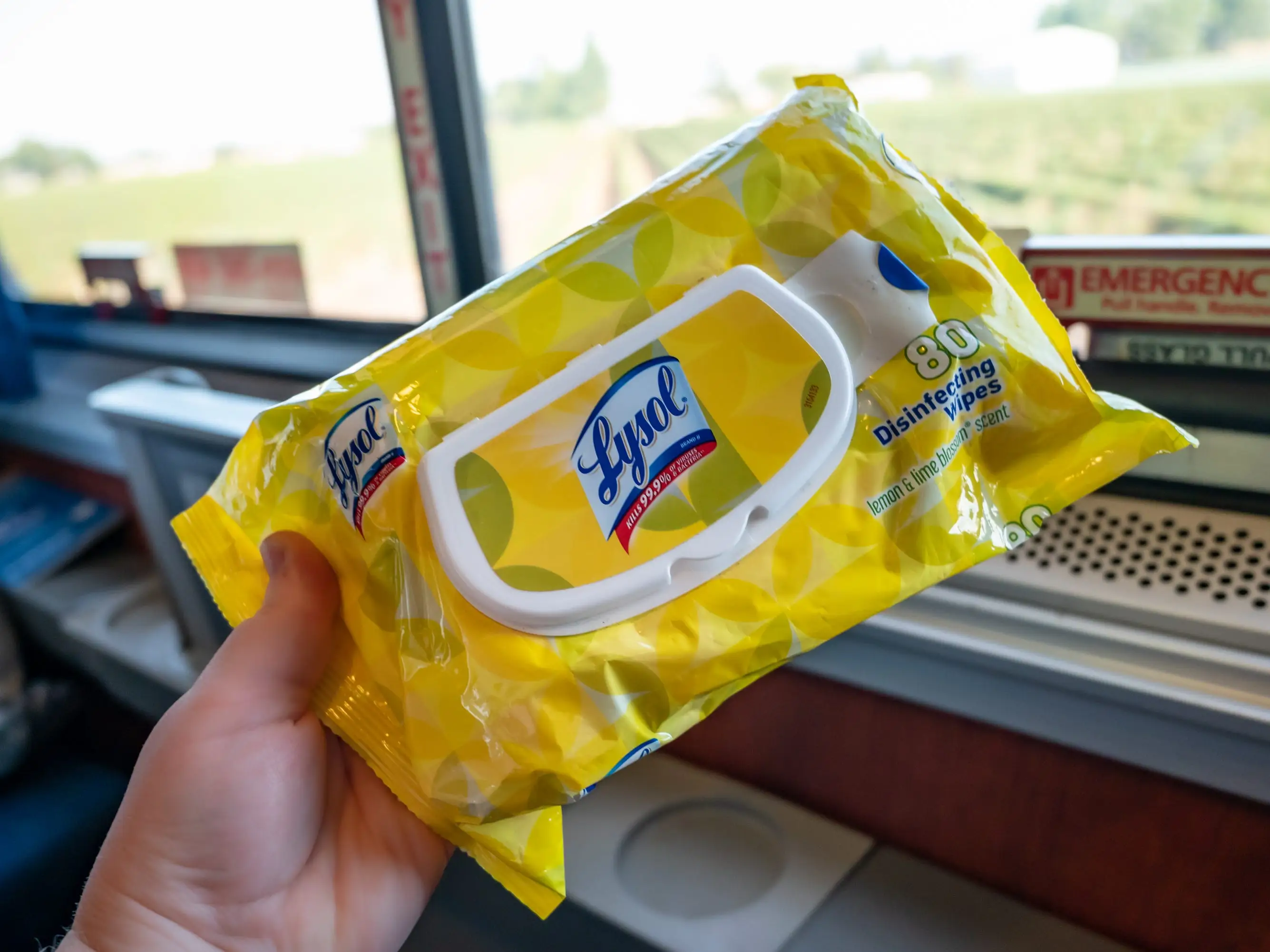 The writer holds a yellow package of Lysol wipes