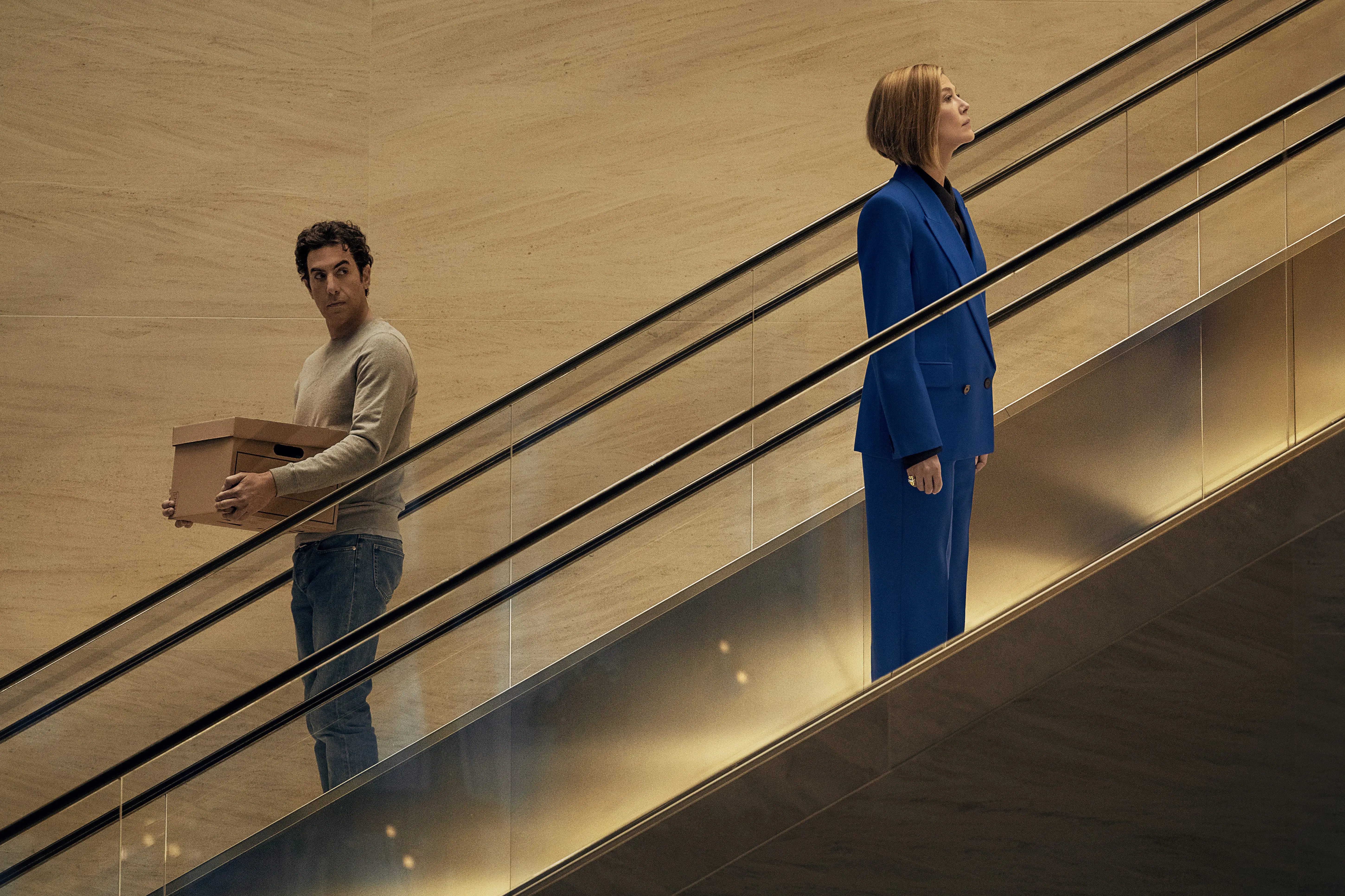 Sacha Baron Cohen and Rosamund Pike riding escalators in Ladies First movie