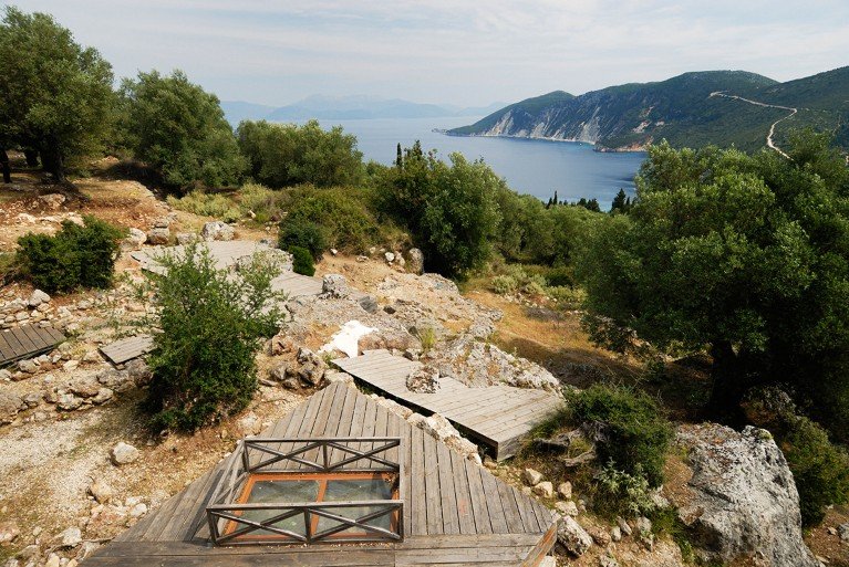 Elevated view over the School of Homer, archaeological site in Ithaki, Greece, showing stones amongst the scrub vegetation close to the coast.
